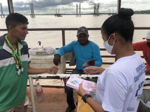 Entrega de folder com tema "Saúde" para os usuários da balsa