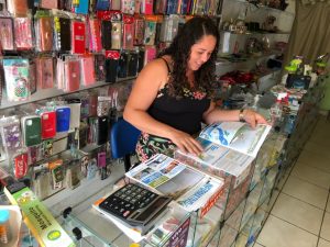 Moradora da região realizando leitura do Informativo da Ponte